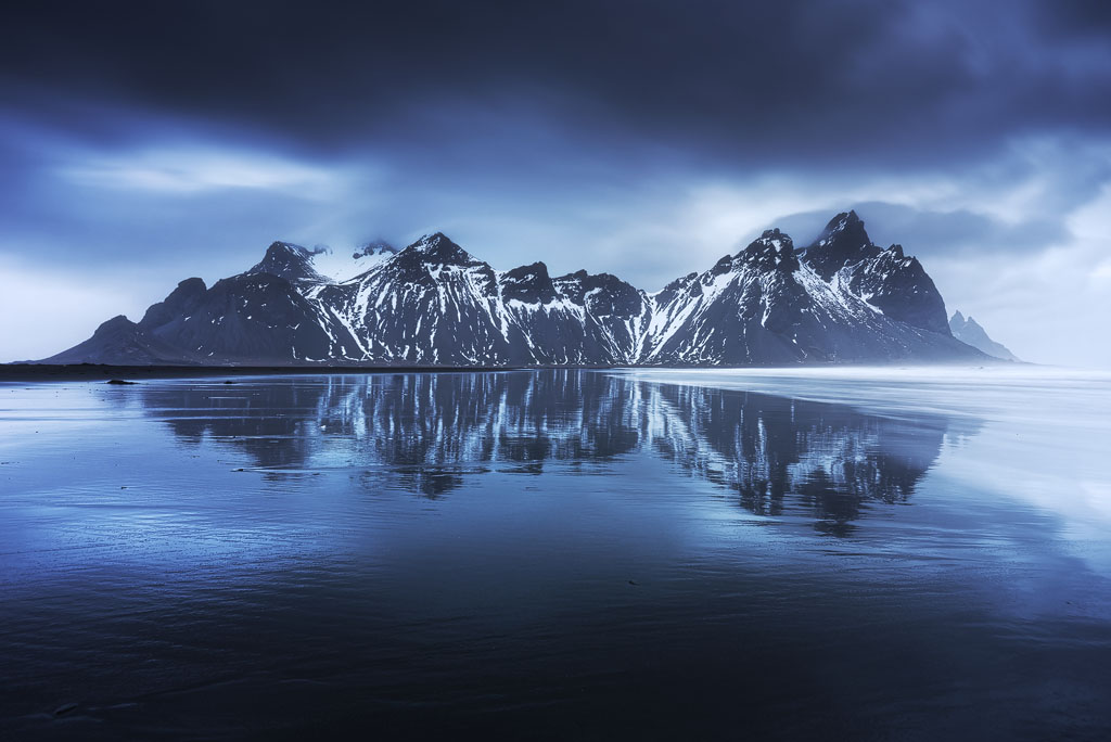Montagnes enneigées et leur reflet sur la plage